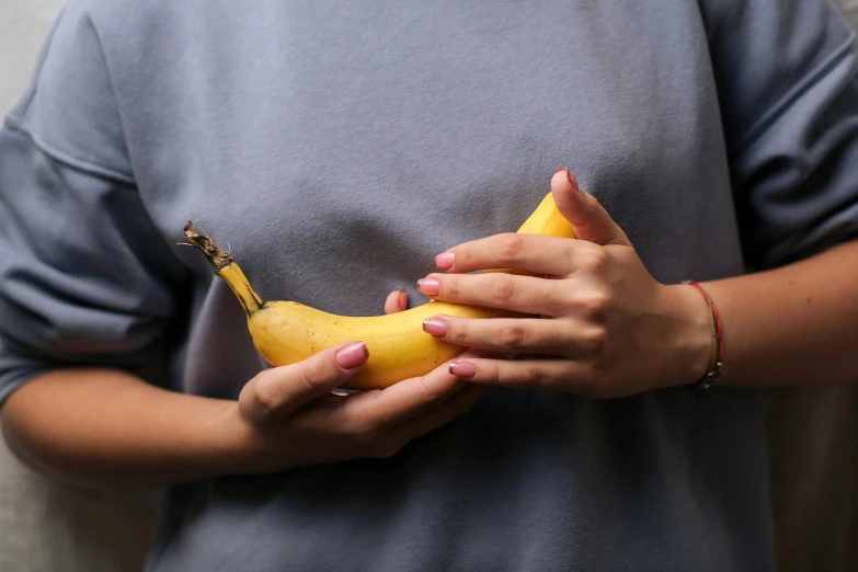 a person holding a banana in their hand