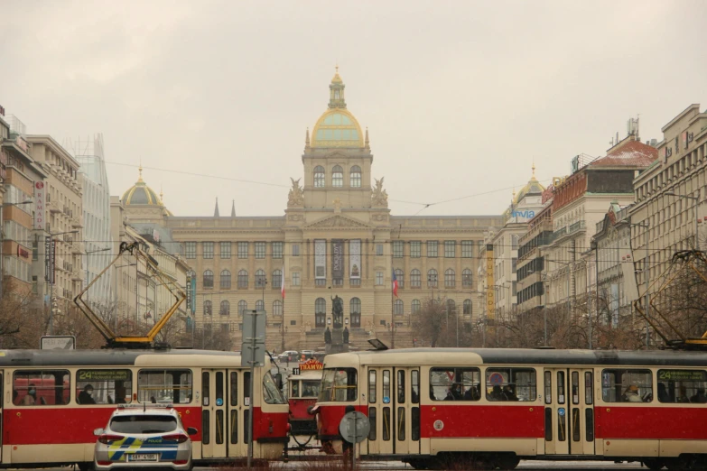 two large buildings and a bunch of trains that are parked