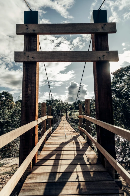 there is a large wooden suspension bridge in the sun