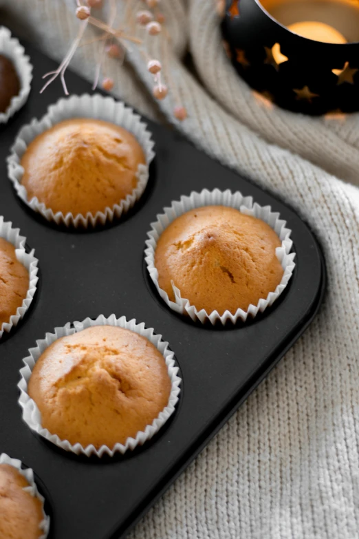 muffins in a muffin pan and a cup of tea