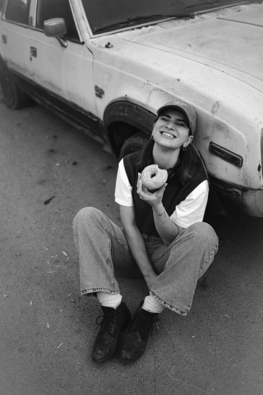 a boy is sitting down eating doughnuts