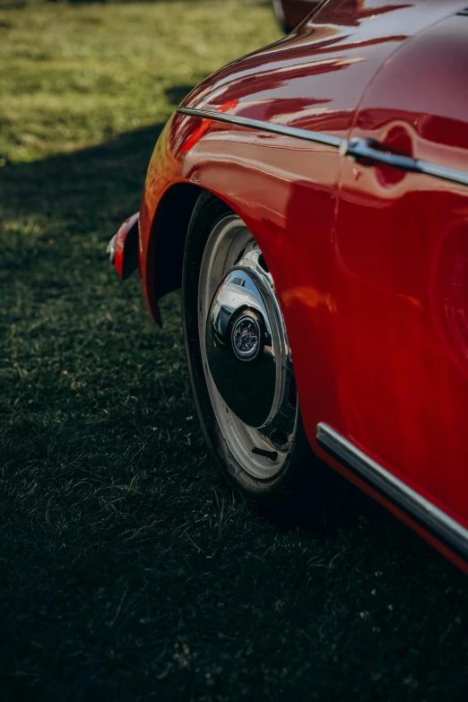 the rear end of an older car sits on the grass