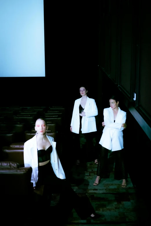 three women in white jackets are posing for the camera