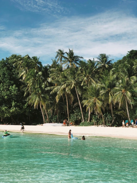 a couple of people standing on a beach next to the ocean