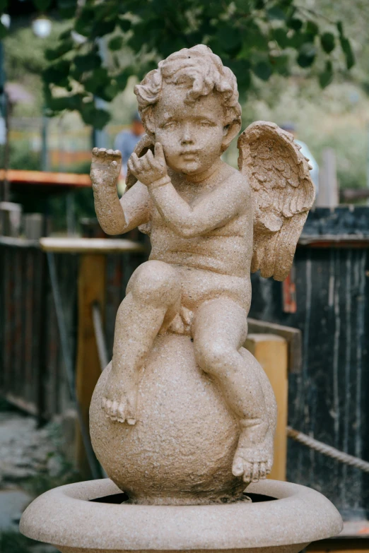 an angel statue is on top of a pedestal