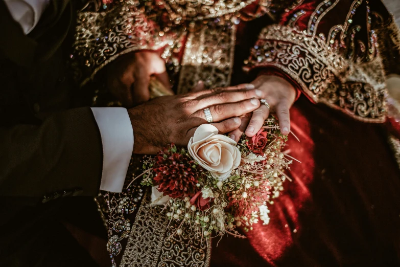 an individual holding onto the wrist of another person in a wedding outfit