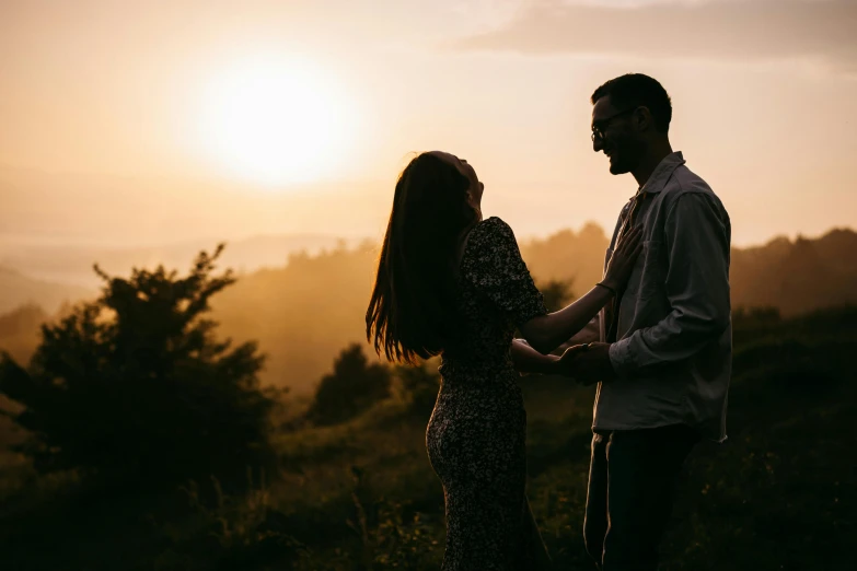 a couple standing next to each other in the mountains