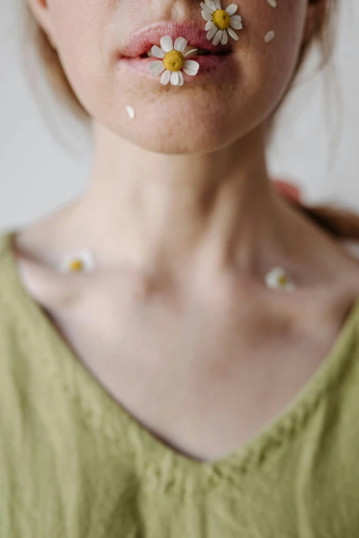 a woman with flowers in her nose looking at the camera