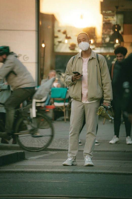 a person standing on the side walk with a mask