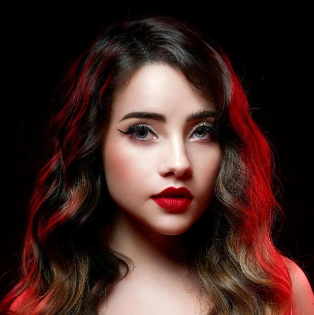 a woman with long, wavy hair in red lipstick is posing for the camera