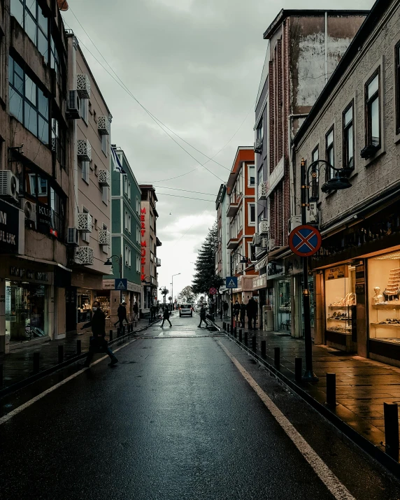 a rainy day down the street where pedestrians walk