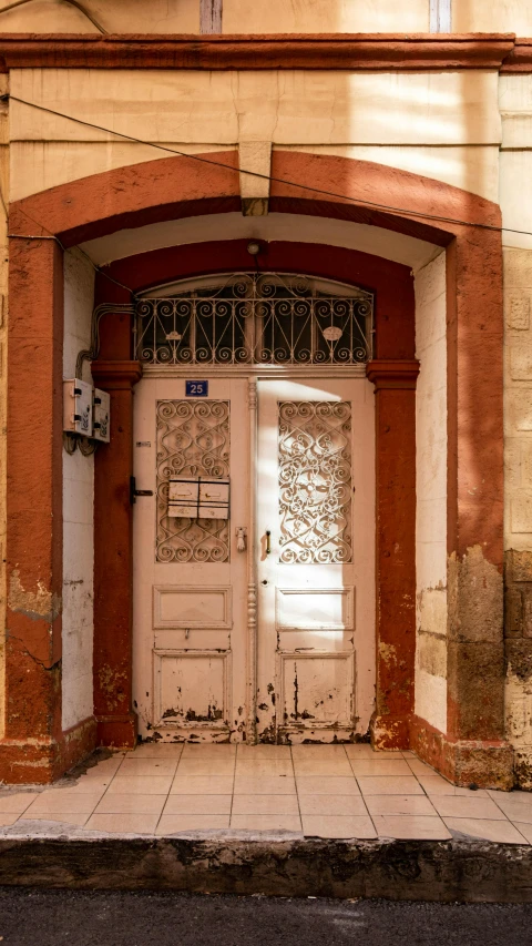 there is a double door and an entry way with graffiti on the side of the building