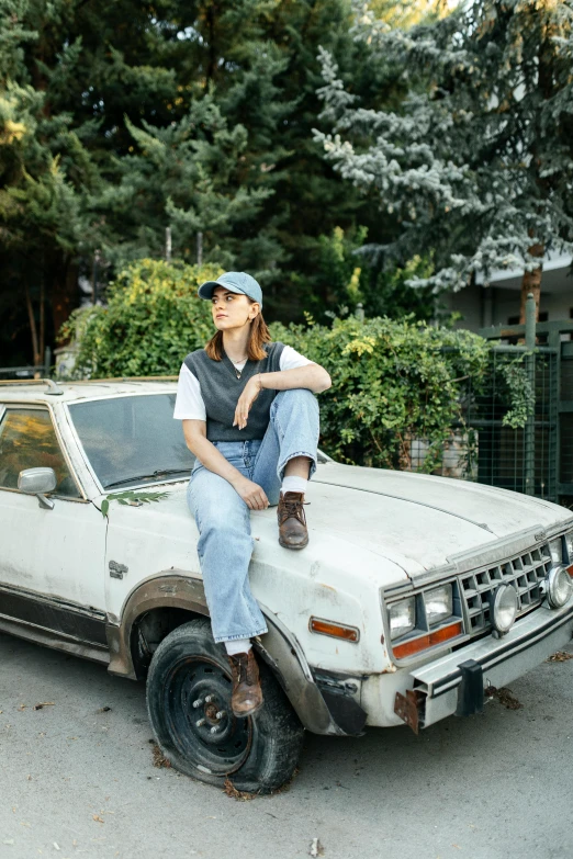 a woman that is sitting on top of an old truck