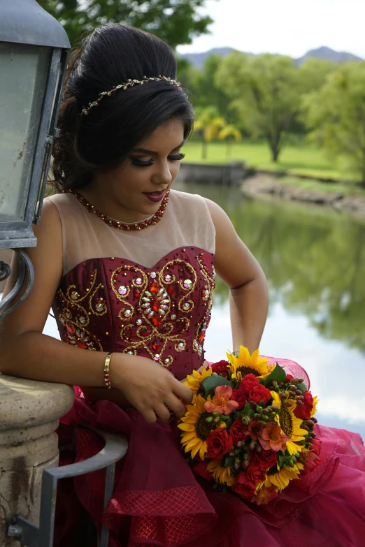 a woman is holding flowers near the water