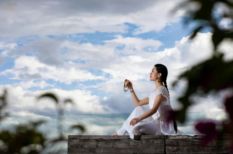 a woman is sitting down on a bench and eating