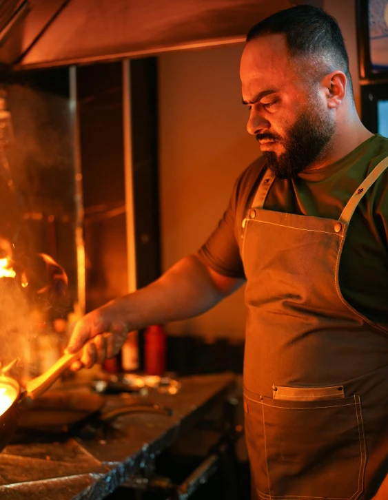 a chef cooking in the kitchen with a wok on the stove