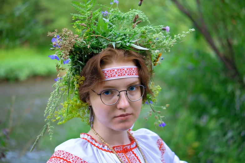 a woman with glasses is wearing a green head band