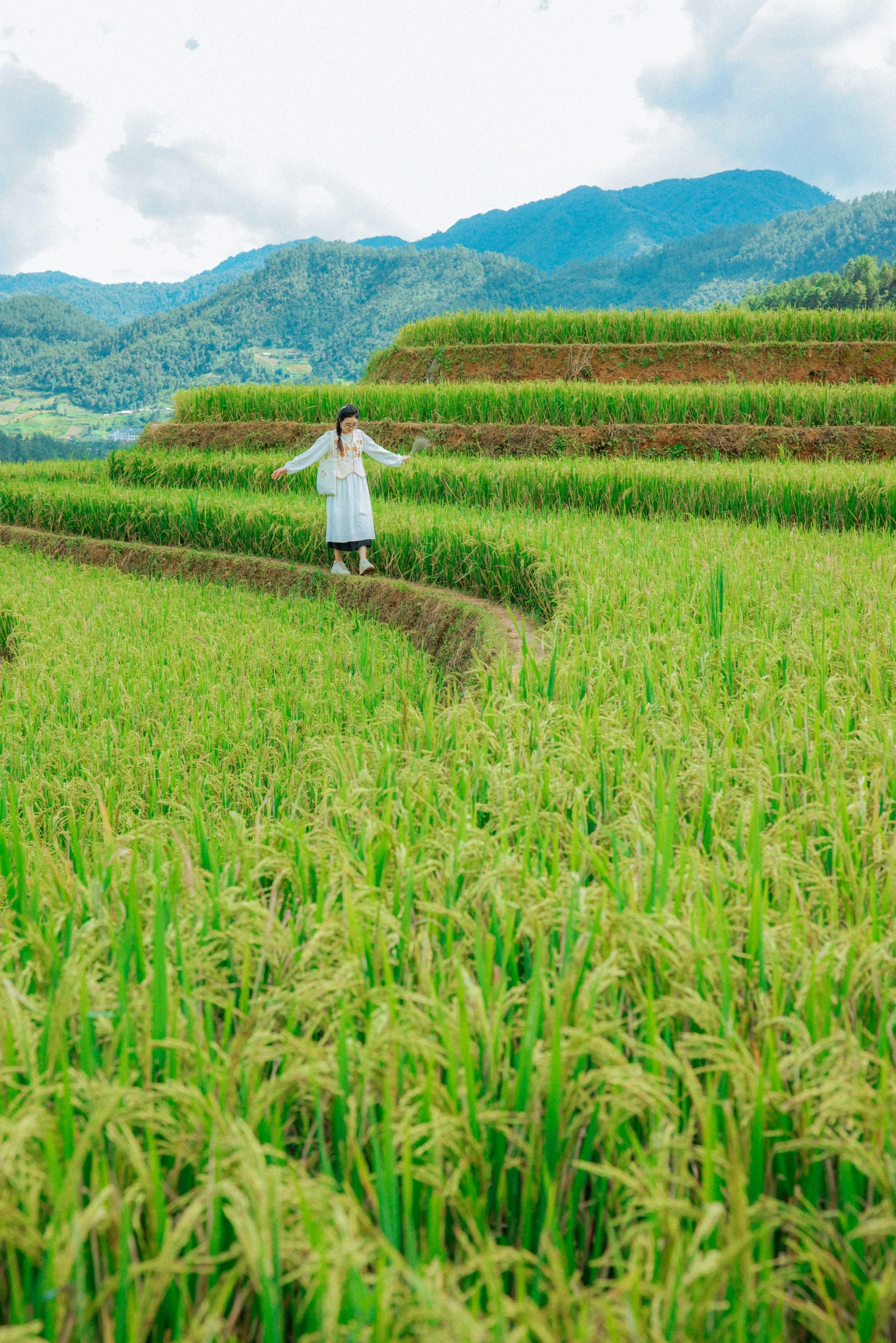 the woman is standing in a huge grassy field