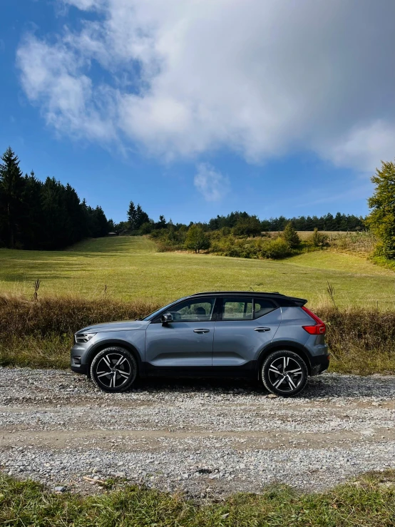 a grey car parked in a gravel area