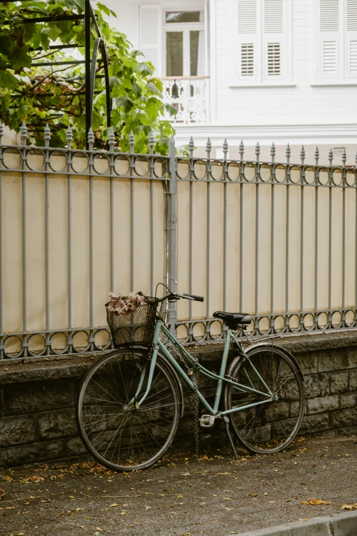 a blue bicycle is leaning against a fence