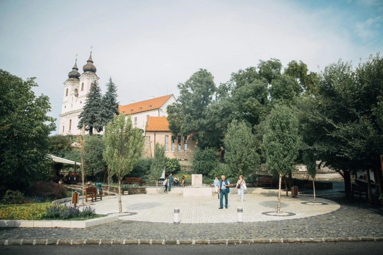 two people are walking in front of an old church