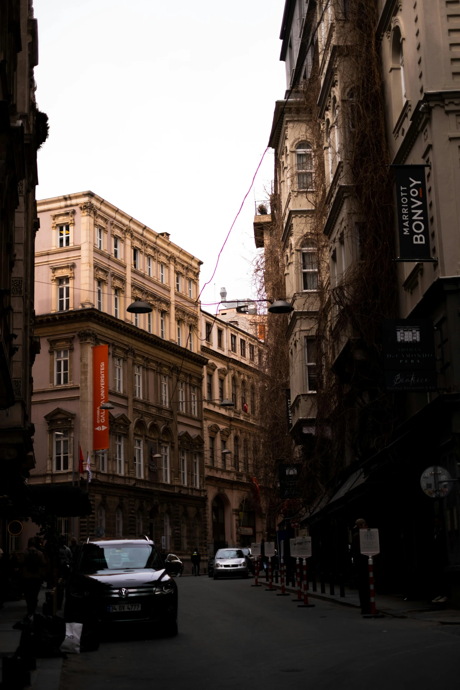 cars driving down the street next to tall buildings