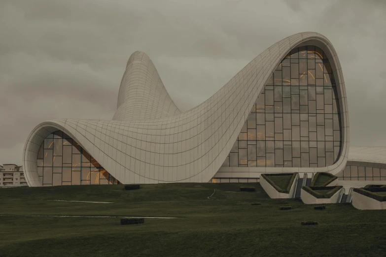 large white building that has a sloping roof and a green lawn