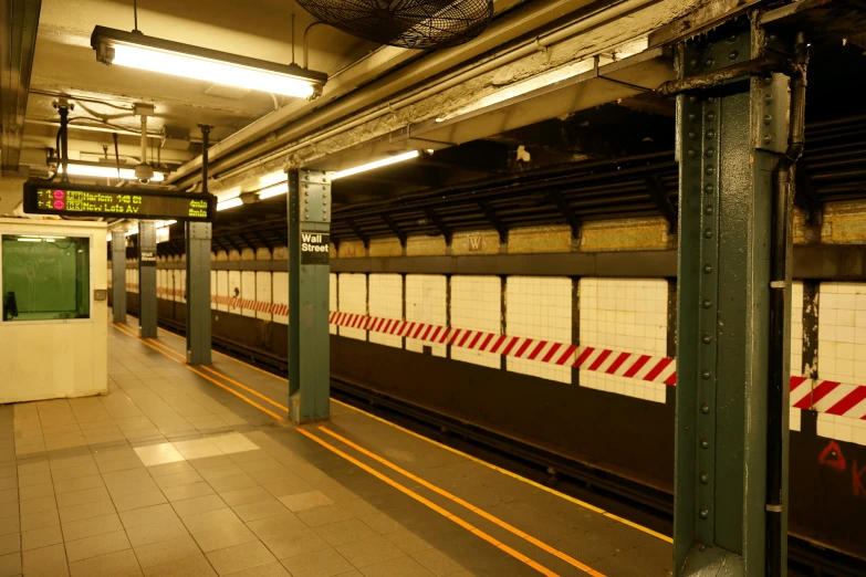 a subway station with an empty wall and yellow stripe around