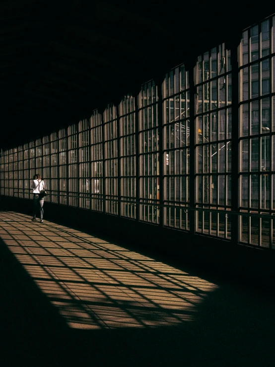 a person walking down a tunnel with a white umbrella