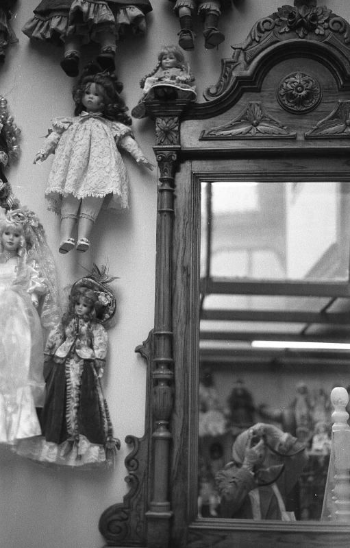 a doll on the shelf above a mirror