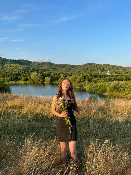 girl standing in field with her arms around her chest