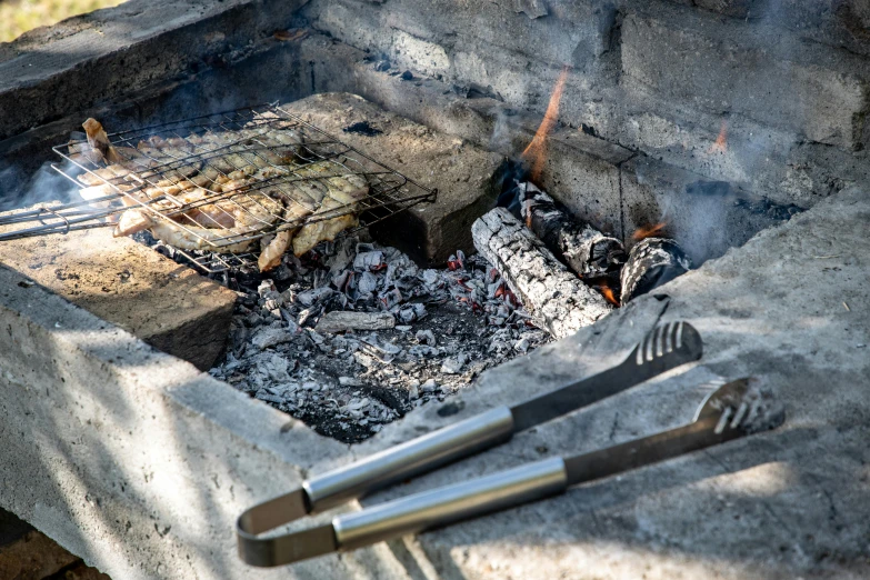 a couple of tongs and tongsticks on top of an outdoor grill