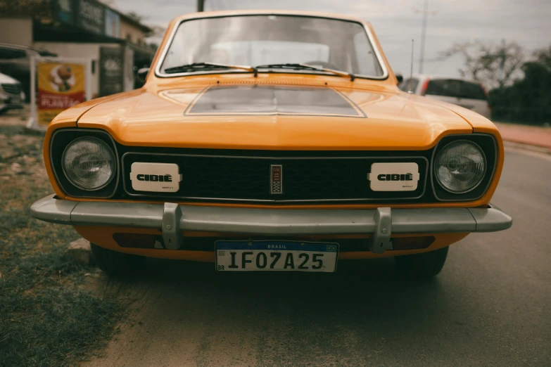 an orange classic car parked in a driveway