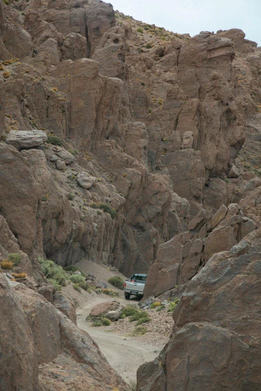 a green truck in the mountains driving away