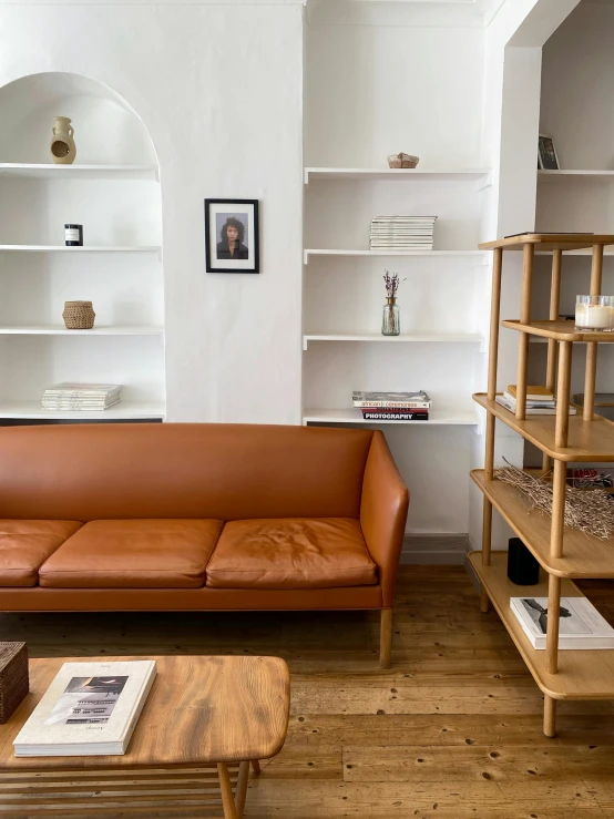 a leather couch sitting next to an open window