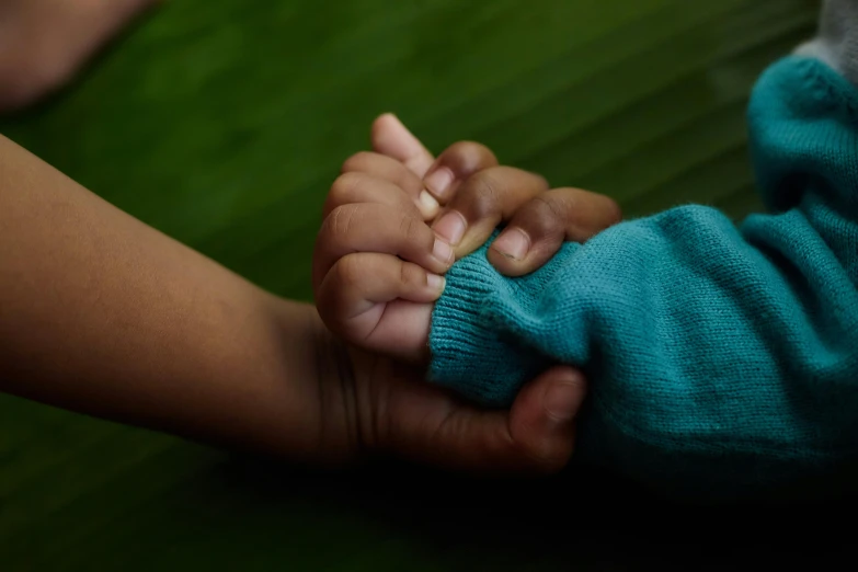 a child's hand is held up by a adult