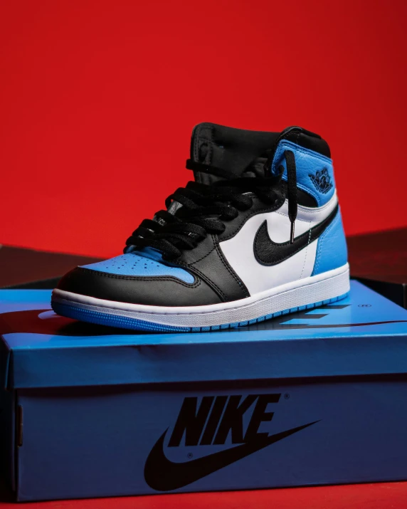 a pair of blue and black sneakers sitting on a shoe box