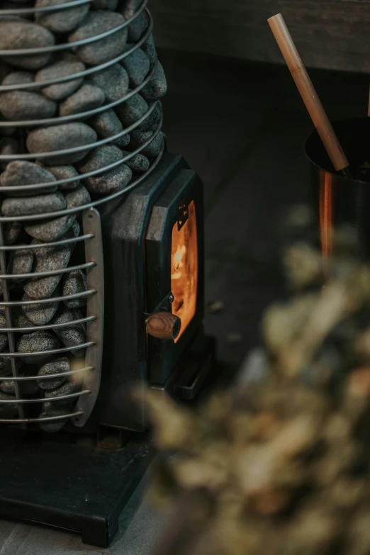 a coal stove with rocks around it is being lit by a flame
