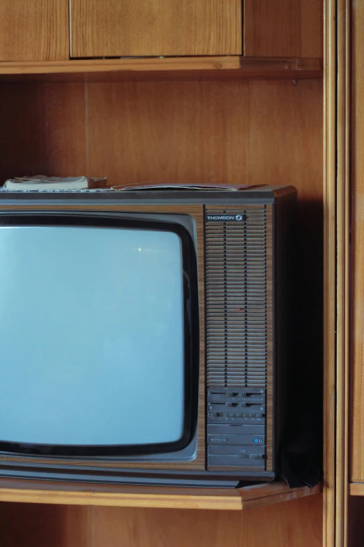 an old television sits on a book shelf