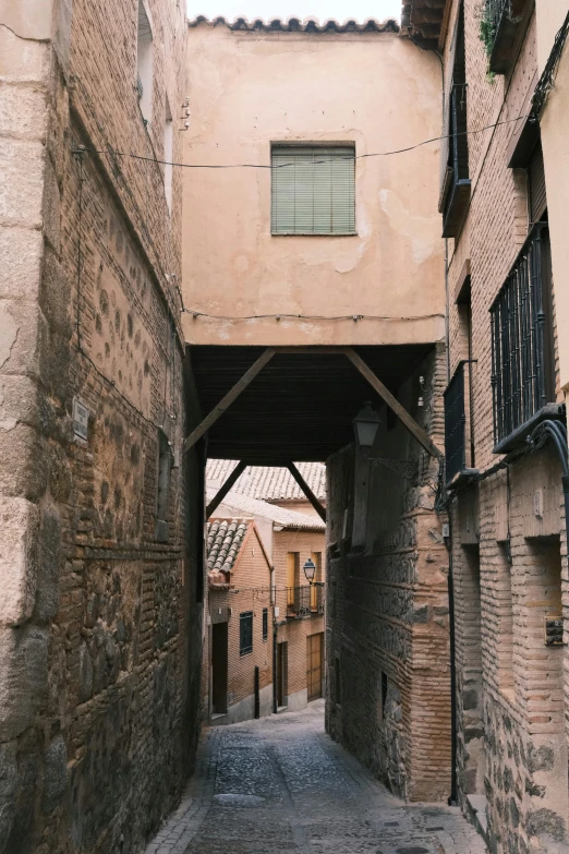 a narrow walkway between two buildings with an awning