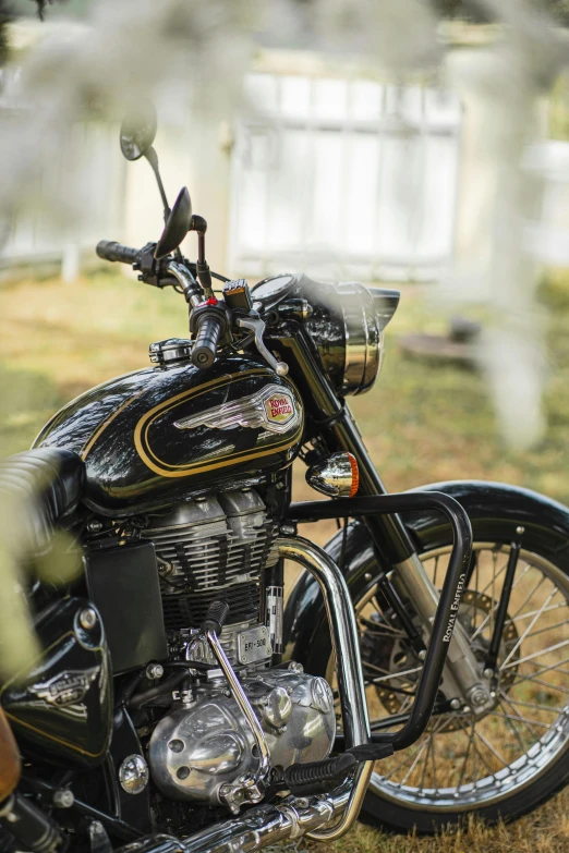 the front end of a black motorcycle parked in a grass field