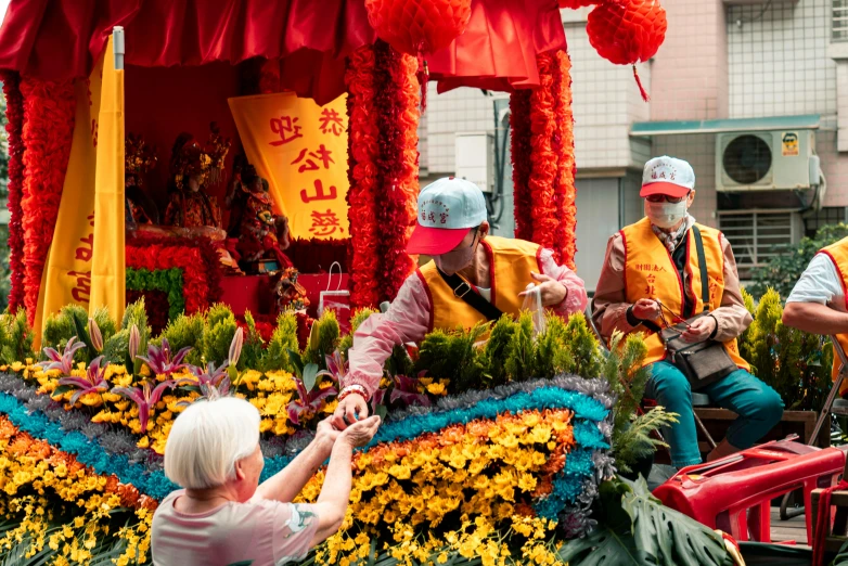 people on a float with colorful flowers and flags