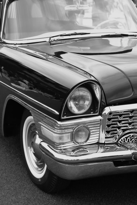 a black car with chrome rims parked next to other cars