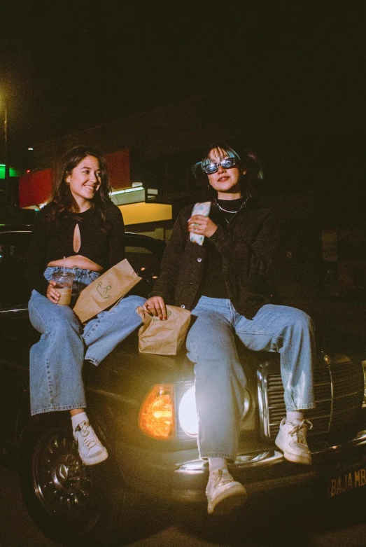 two people sit on the back of a pick up truck