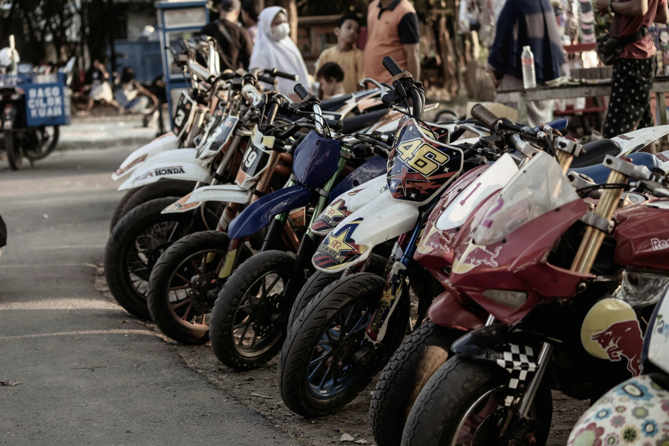 a line up of parked motor bikes on the side of a road