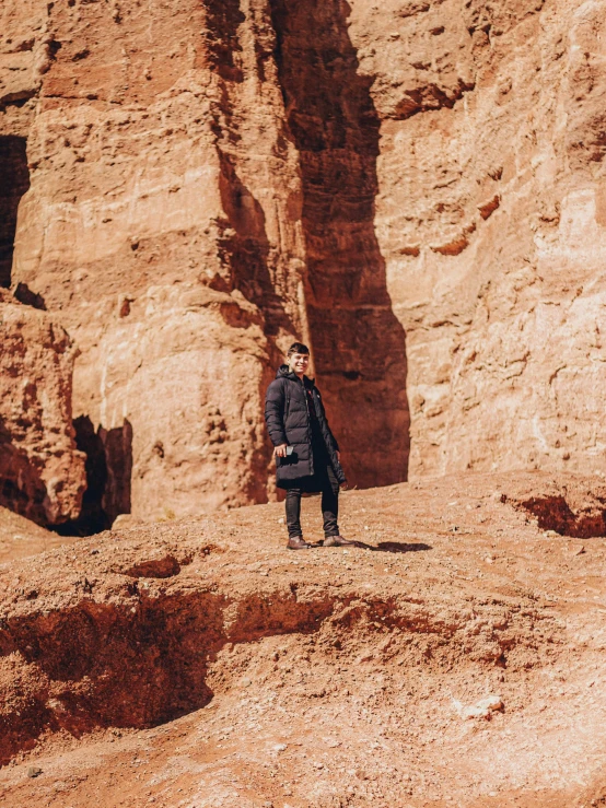 a man in black standing on rocky ground