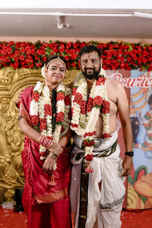 a man and a woman standing close together in front of a stage