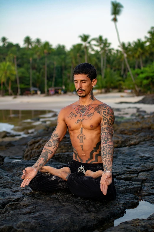 a man meditating on the rocky shore