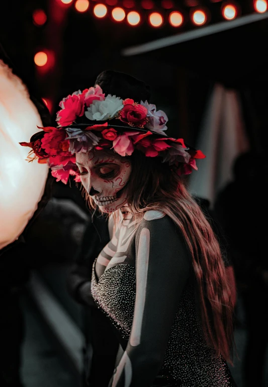 a woman in a skull mask with flowers on her head