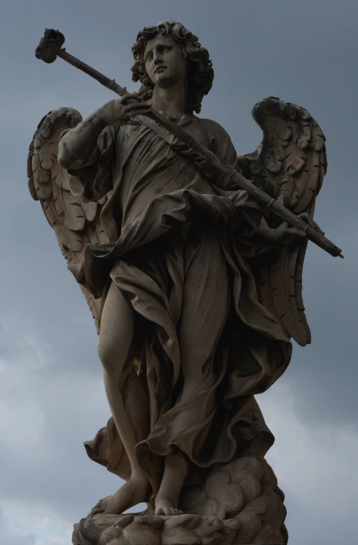 a statue of a man with a staff is pictured against the grey sky